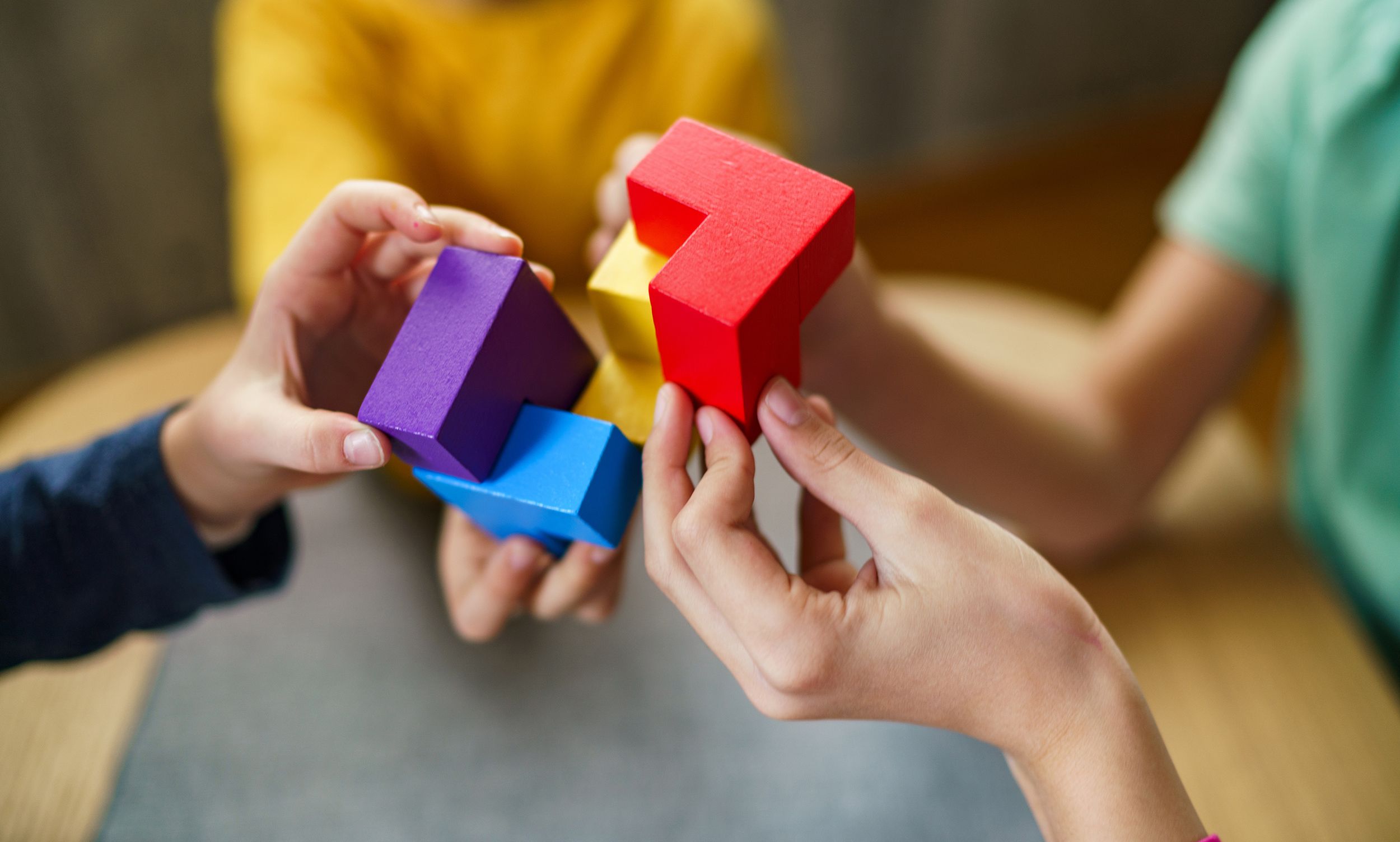 Children playing with colorful puzzle blocks.